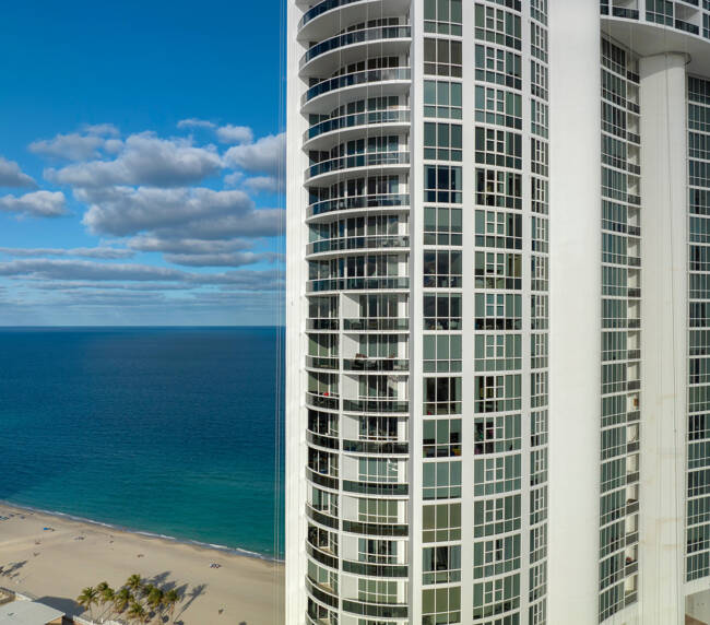 High angle view of Sunny Isles Beach city with expensive highrise hotels and condo buildings on Atlantic ocean shore. American tourism infrastructure in coastal southern Florida